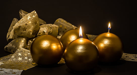 four gold-colored candles beside brown textile thumbnail