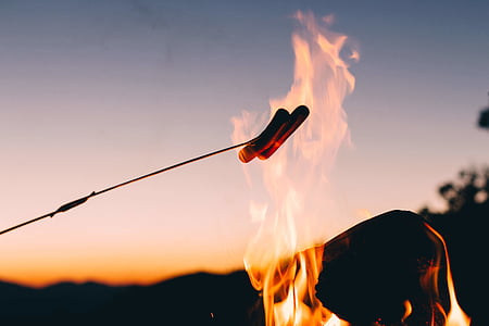 person grilling two sausages during daytime thumbnail