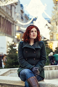 woman with double breasted coat sitting on concrete thumbnail