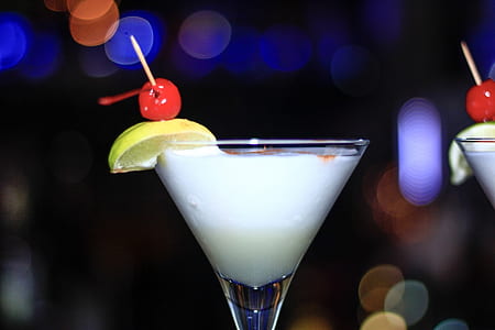 martini glass filled with white liquid in selective focus photo thumbnail