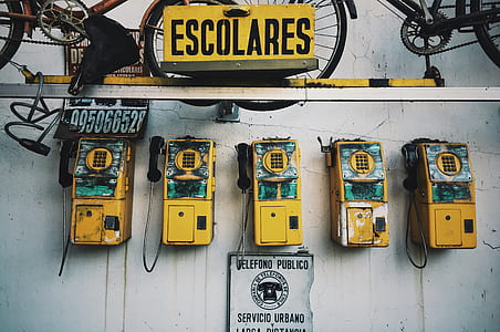 five yellow payphones on wall thumbnail