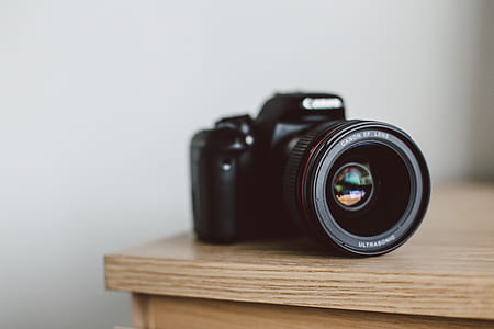 selective focus photography of Canon DSLR camera on brown table thumbnail