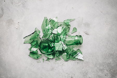 broken green glass bottle on gray concrete pavement thumbnail