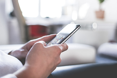 Woman Using Her iPhone At Home Office thumbnail
