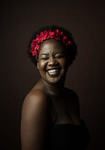 selective focus photography of smiling woman wearing red flower headband thumbnail