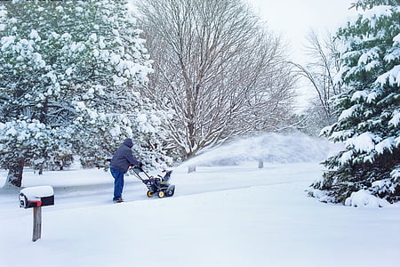person using snow blower surrounded by trees thumbnail