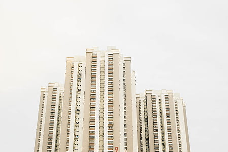low angle photo of beige high-rise building over cloudy sky at daytime thumbnail