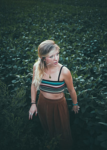woman standing and surrounded by green plants thumbnail