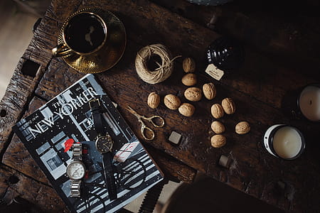 New Yorker, some nuts, watches, and other things on the old, wooden table thumbnail