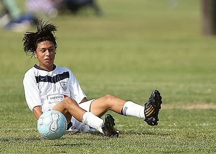 soccer player lying on grass field thumbnail