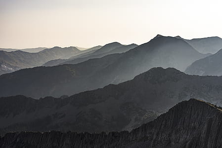brown mountains under cloudy sky during daytime thumbnail