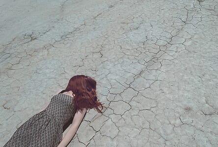 person in grey and black sleeveless dress lying on grey concrete road thumbnail