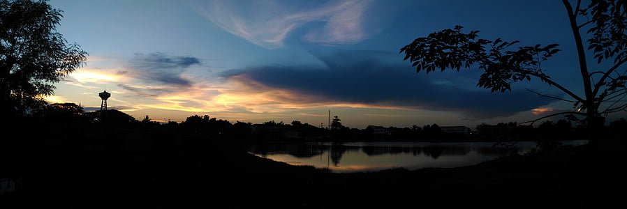 silhouette of trees near body of water during golden hour thumbnail