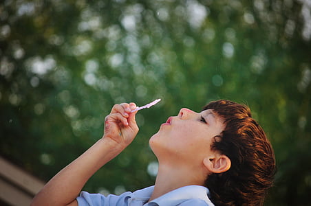 selective focus photography of boy blowing bubble toy thumbnail