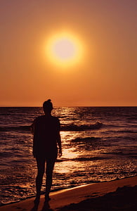 silhouette of woman standing on shore thumbnail