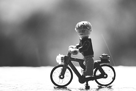 grayscale photography of man riding on bike toy thumbnail