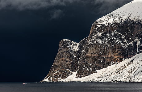 snow covered mountain near body of water thumbnail