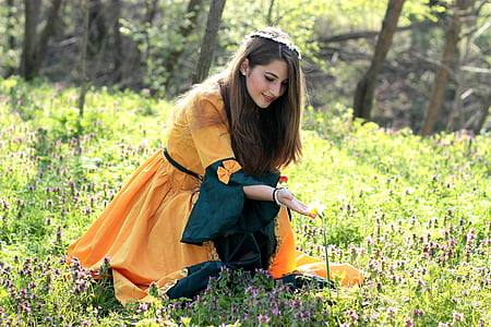 woman touching flower at the field during day thumbnail