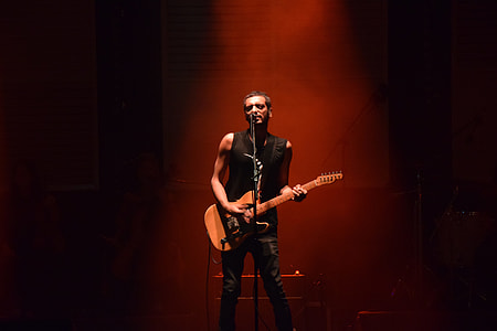 man playing guitar and singing on the microphone thumbnail