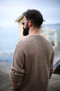rear photography of man wearing brown long-sleeved shirt and sunglasses thumbnail