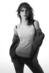 woman wearing white tank top and denim jacket posing on white background thumbnail