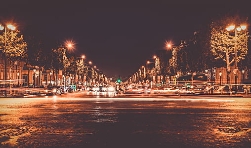 Lighted Street With Cars Passing by during Nighttime thumbnail