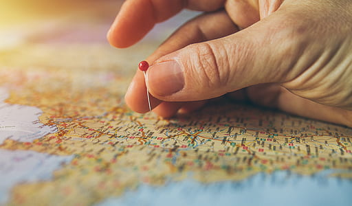 person holding pin on map thumbnail