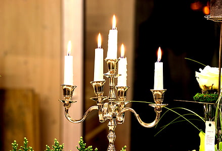 five white lighted candles on brown holder thumbnail