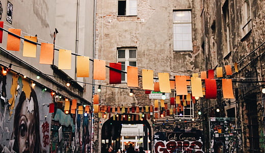red and yellow lanterns between concrete buildings thumbnail