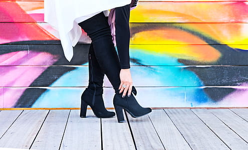 Photo of Woman Touching Right Heeled Shoe Beside Wall thumbnail