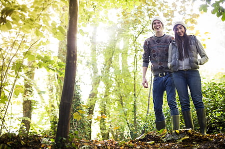 man and woman walking on forest during daytime thumbnail