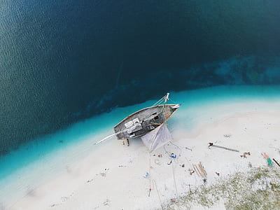 high-angle photo of gray and white fishing boat on seashore during daytime thumbnail