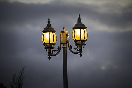 lit black lamppost under cloudy sky thumbnail