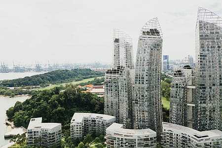 photo of gray concrete buildings near green leaf trees at daytime thumbnail