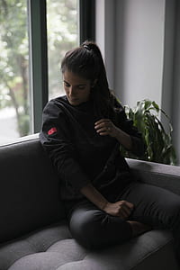 woman sitting on sofa near glass window thumbnail