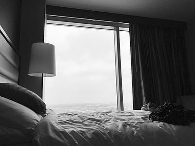 white bed beside window and pedestal lamp thumbnail