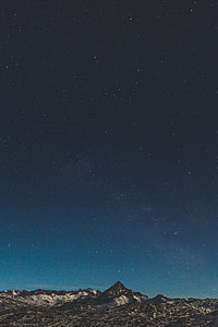 gray rock mountains under black sky at nighttime thumbnail