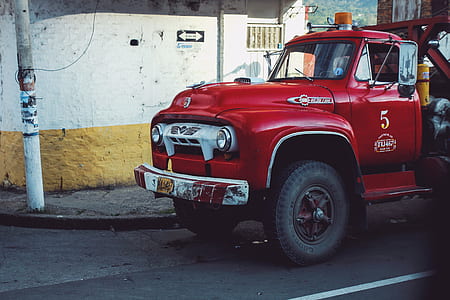 red 2-door truck park on asphalt road thumbnail