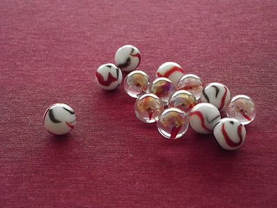 white and clear marble toys on red pad thumbnail