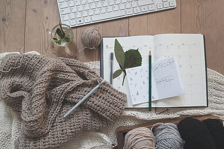 yarn and notebook with pencil on table thumbnail