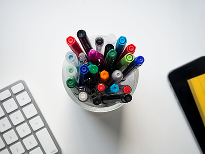 assorted-color pens in clear cup thumbnail