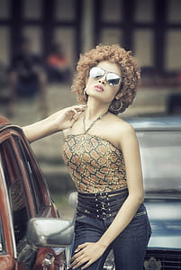 woman wearing brown and black snakeskin halter top near blue vehicle thumbnail
