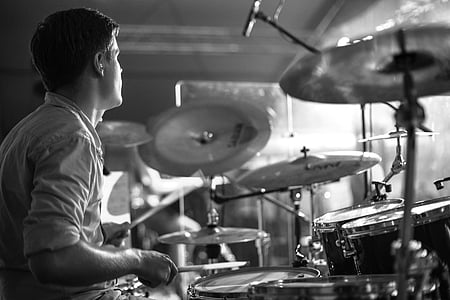 grayscale photography of man wearing collared shirt playing drum thumbnail