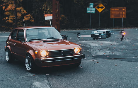brown 5-door hatchback on road near drone thumbnail