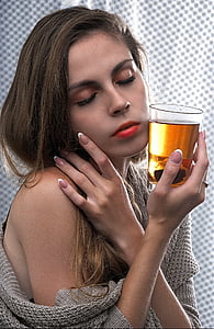woman wearing gray sweater holding drinking glass thumbnail