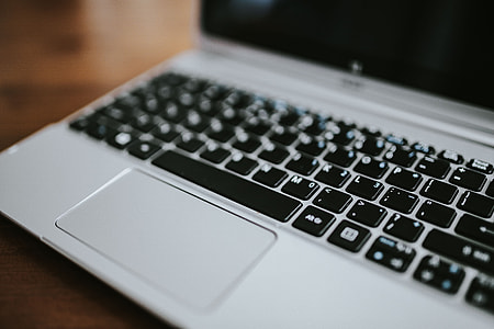 Silver laptop with various items on a table thumbnail