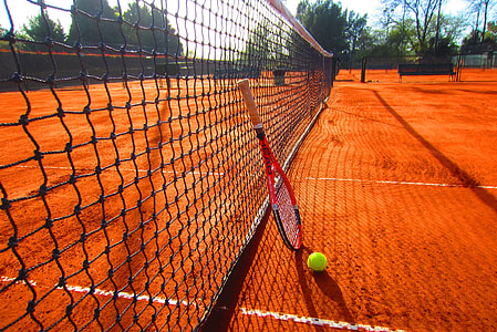 red and black tennis racket leaning on net thumbnail