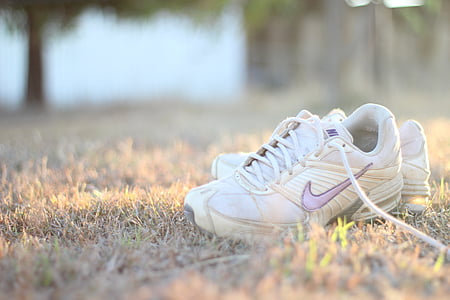 white-and-purple Nike shoes on grass field thumbnail