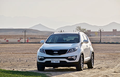 white Kia Sportage on sand thumbnail