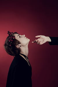 woman facing upwards while person reaching woman's chin thumbnail